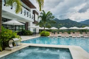 a swimming pool in front of a building with chairs and umbrellas at Casa Noral Hotel in Copacabana