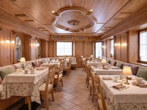 ein Esszimmer mit Tischen und Stühlen und einer Decke in der Unterkunft Central Heritage Adults Only in Moena + 16 Fotos