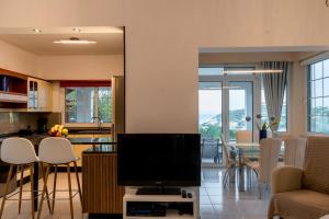 a living room with a television and a dining room at Monte Mare Rhodes in Ixia