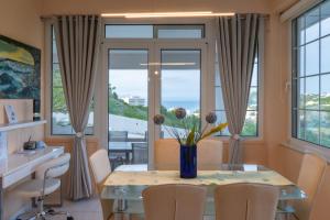a dining room with a table and chairs and windows at Monte Mare Rhodes in Ixia