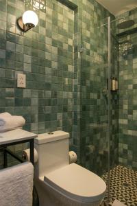 a bathroom with a toilet and a glass shower at Motto By Hilton Cusco in Cusco +100 photos