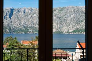 a view of a lake and mountains from a window at Horizon Apartments in Prčanj