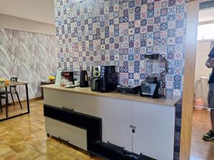 a kitchen with a counter and a tile wall at Studio chamorso - Cama Queen - AC - Garagem in Rondonópolis