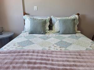 a bed with a quilt and pillows on it at Studio chamorso - Cama Queen - AC - Garagem in Rondonópolis +24 photos