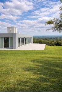 a house on top of a grassy field at Casa refugio in Santa María