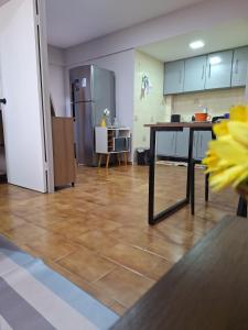 a kitchen with a table and a refrigerator at Studio chamorso - Cama Queen - AC - Garagem in Rondonópolis