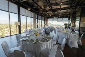 a banquet hall with white tables and chairs and windows at Hotel Terrado Rancagua in Rancagua +20 photos