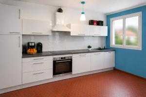 a kitchen with white cabinets and a window at Séjour bercé par la Mer in Jard-sur-Mer