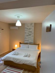 a bedroom with a white bed with two glasses on it at Trakos Home Hotel in Korçë