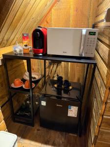 a microwave sitting on a table next to a coffee maker at A Cabana Caiçara in Ilhabela