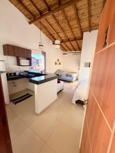 a kitchen with white cabinets and a black counter top at Pousada Portal da Mucugê in Porto Seguro