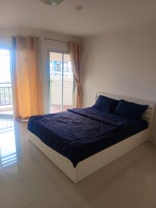 a bedroom with a bed with blue sheets and a window at Pattaya Center Point Condo in Pattaya