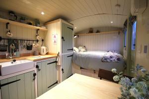 a kitchen and a bedroom in a tiny house at Spinney Wood Glamping, Oak Hut in Bewdley