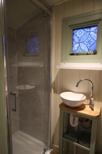 a bathroom with a sink and a glass shower at Spinney Wood Glamping, Oak Hut in Bewdley +21 photos