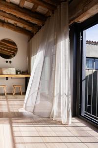 a room with a window with white curtains at Mas Escarrà in Caldes de Malavella