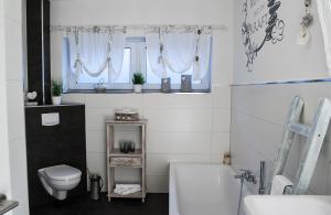 a bathroom with a tub and a toilet and a sink at Ferienwohnung Viva la Vida in Bendorf +26 photos