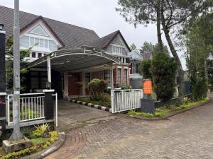 a house with an arbor in front of it at Eton Asia Villas-Kota Bunga in Puncak
