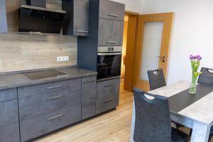 a kitchen with gray cabinets and a table with chairs at Auszeit im Sauerland in Meschede