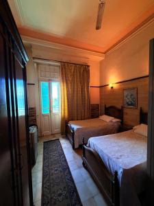 a hotel room with two beds and a window at Fouad Hotel in Alexandria