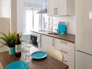 a kitchen with a table with a bottle of wine at Flores in Málaga