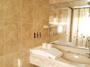a bathroom with a sink and a mirror at Cordelius Hotel in Puno