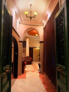 a hallway with a living room and a chandelier at Fouad Hotel in Alexandria +12 photos
