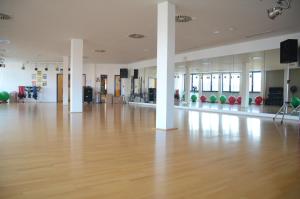 a large room with a wooden floor and white columns at Hotel Ambiente in Halberstadt