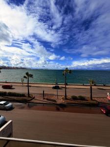 a view of the ocean with palm trees and a street at Fouad Hotel in Alexandria