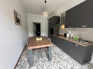 a kitchen with a wooden table and a sink at Casa Serena in Baveno