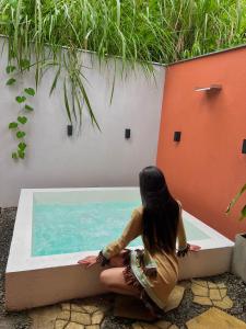 a woman sitting next to a swimming pool at Glamping Raíces in Manizales