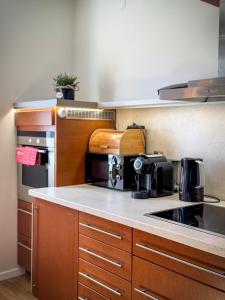 a kitchen with wooden cabinets and a stove top oven at Apartament Piastowska in Ostróda