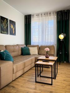 a living room with a couch and a table at Apartament Piastowska in Ostróda