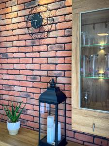 a black lantern in front of a brick wall at Apartament Piastowska in Ostróda