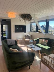 a living room with two couches and a table at Stay by pramskoven in Køge
