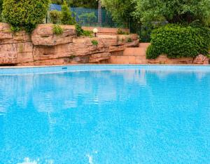 a large swimming pool with blue water at Studio Premium au Calme avec Terrasse Vue Mer et Parking in Nice