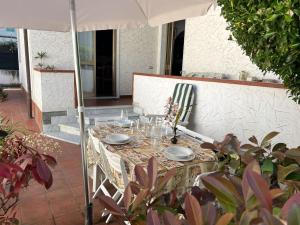a table with chairs and an umbrella on a patio at Casa Nina in Marina di Massa