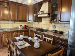 a kitchen with wooden cabinets and a table with chairs at Casa Nina in Marina di Massa +9 photos