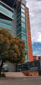 a tall building with a tree in front of it at Hotel San Silvestre in Barrancabermeja