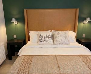 a large bed with pillows on it with two tables at Increible Chalet en La Parva in Santiago
