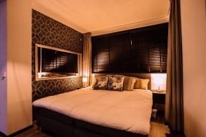 a bedroom with a large bed with a window at B&W Malina Jacuzzi Suite in Lelystad