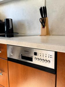 a kitchen counter with a microwave and a knife block at Apartament Piastowska in Ostróda +40 photos