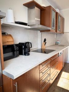 a kitchen with wooden cabinets and a counter top at Apartament Piastowska in Ostróda