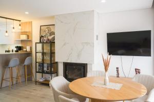 a dining room with a table and a fireplace at Ofir Nature Stay in Fão