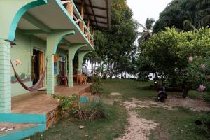 a blue house with a porch and a yard at Guesthouse Island Escape in Corn Islands