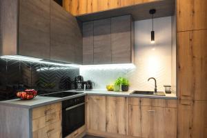 a kitchen with wooden cabinets and a sink at Willa Szycha in Karpacz +55 photos