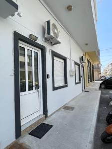 a white building with a door and a fan at Emari Apartments in Heraklio