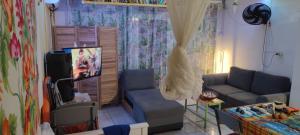 a living room with a couch and a tv at Cocon Alizé - Studio cozy, Port-Louis centre, plage à 10 min à pied in Port-Louis