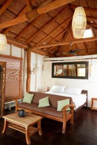 a living room with a couch and a bed at Sohla Hotel Popoyo in Playa Santana