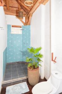 a bathroom with a toilet and a potted plant at Sohla Hotel Popoyo in Playa Santana
