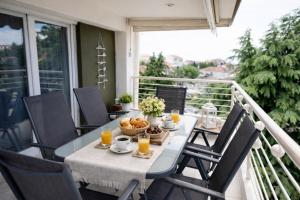 a table and chairs on a balcony with orange juice at Epanomi Family Apartments in Epanomi